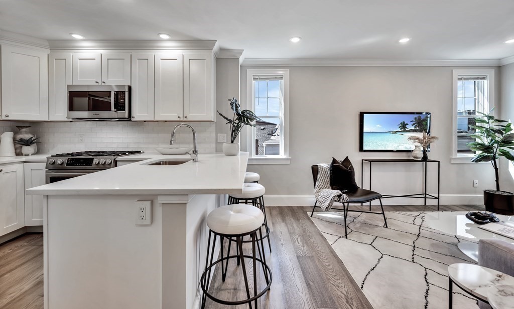 9 R Trenton Street, Unit 1 Boston, MA 02128 - Photo 11 of 15 a kitchen with stainless steel appliances a table and chairs in it