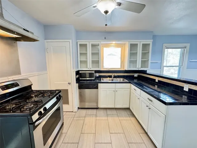 a kitchen with a stove and white cabinets