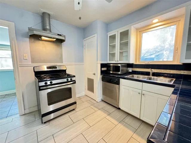 a kitchen with stainless steel appliances a stove a sink and a microwave