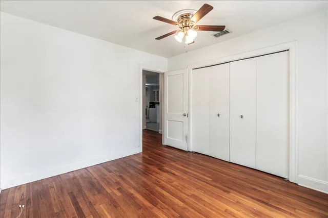 a view of a big room with wooden floor and a ceiling fan