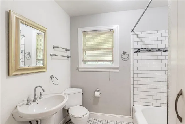 a bathroom with a toilet a sink a mirror and a shower