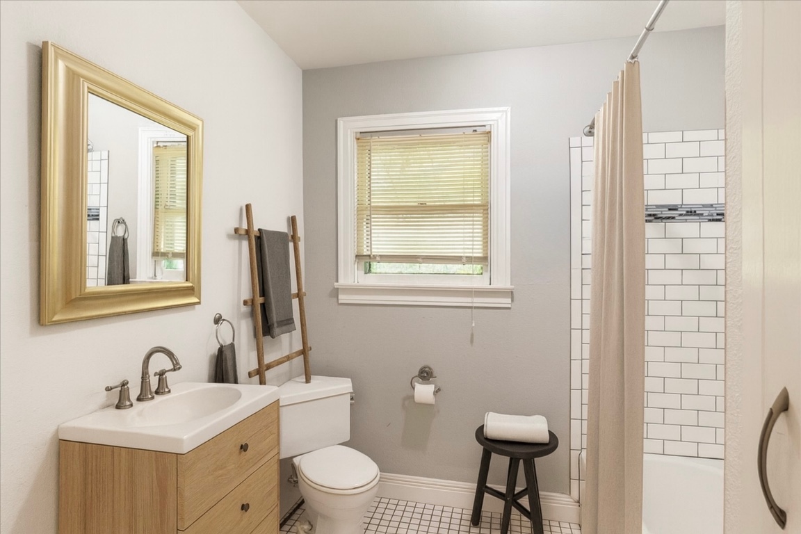 3710 Hollywood Avenue Austin, TX 78722 - Photo 5 of 39 a bathroom with a toilet a sink a mirror a window and vanity