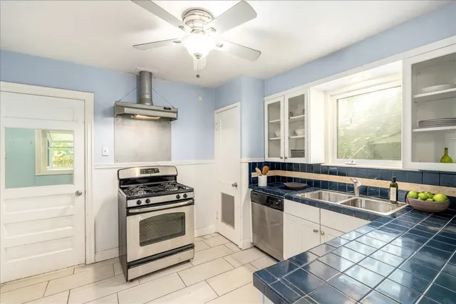 a kitchen with stainless steel appliances a stove a sink and a refrigerator
