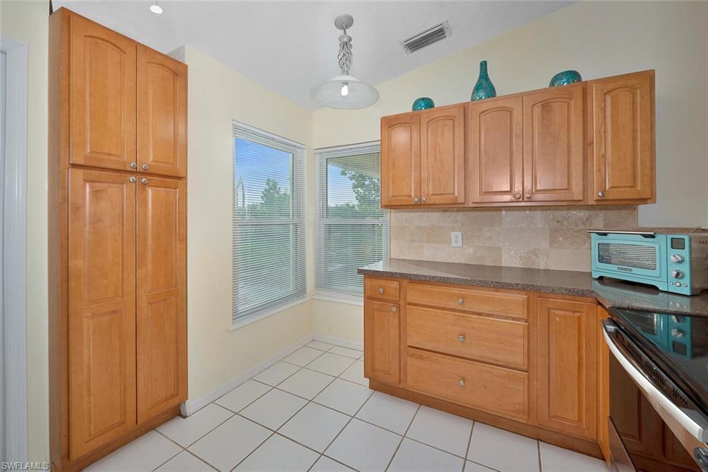 1981 Seminole Harbor Drive Alva, FL 33920 - Photo 9 of 19 a kitchen with granite countertop wooden cabinets and white appliances