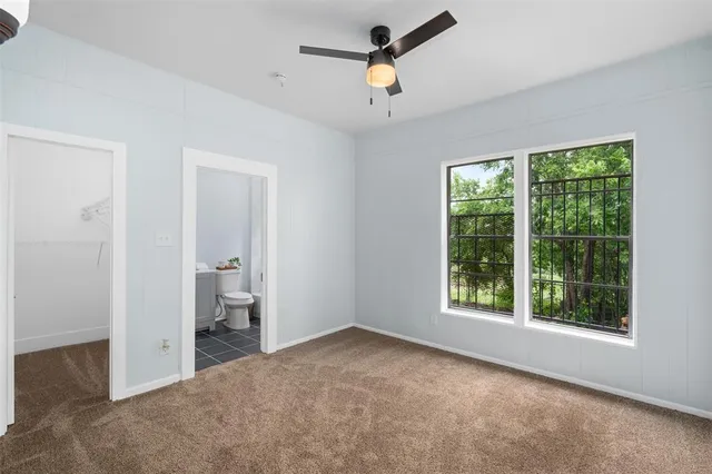 a view of a room with a ceiling fan and a window