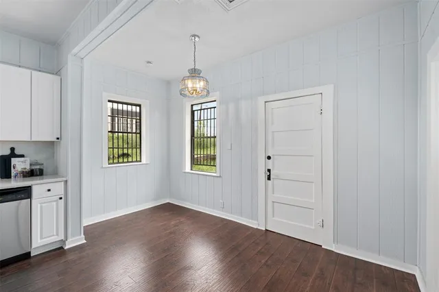 a view of empty room with wooden floor and window