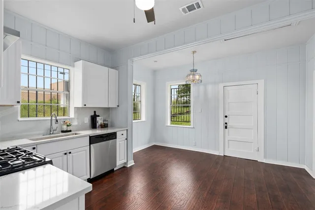 a kitchen with a sink wooden floor and window