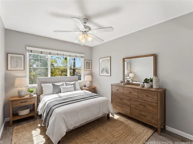 an empty room with wooden floor and a ceiling fan