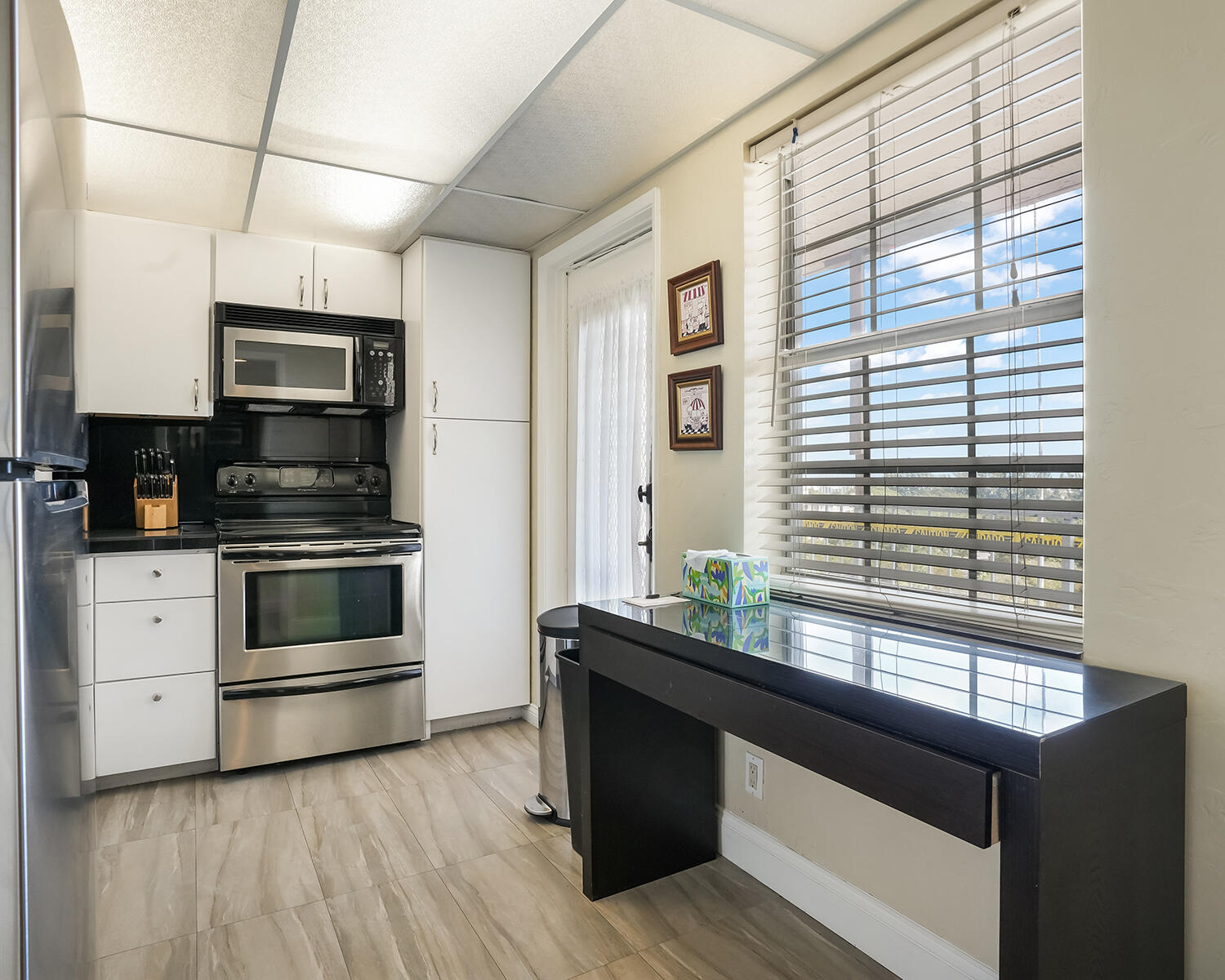 2671 South Course Drive, Unit 907 Pompano Beach, FL 33069 - Photo 12 of 21 a kitchen with granite countertop a stove and a microwave