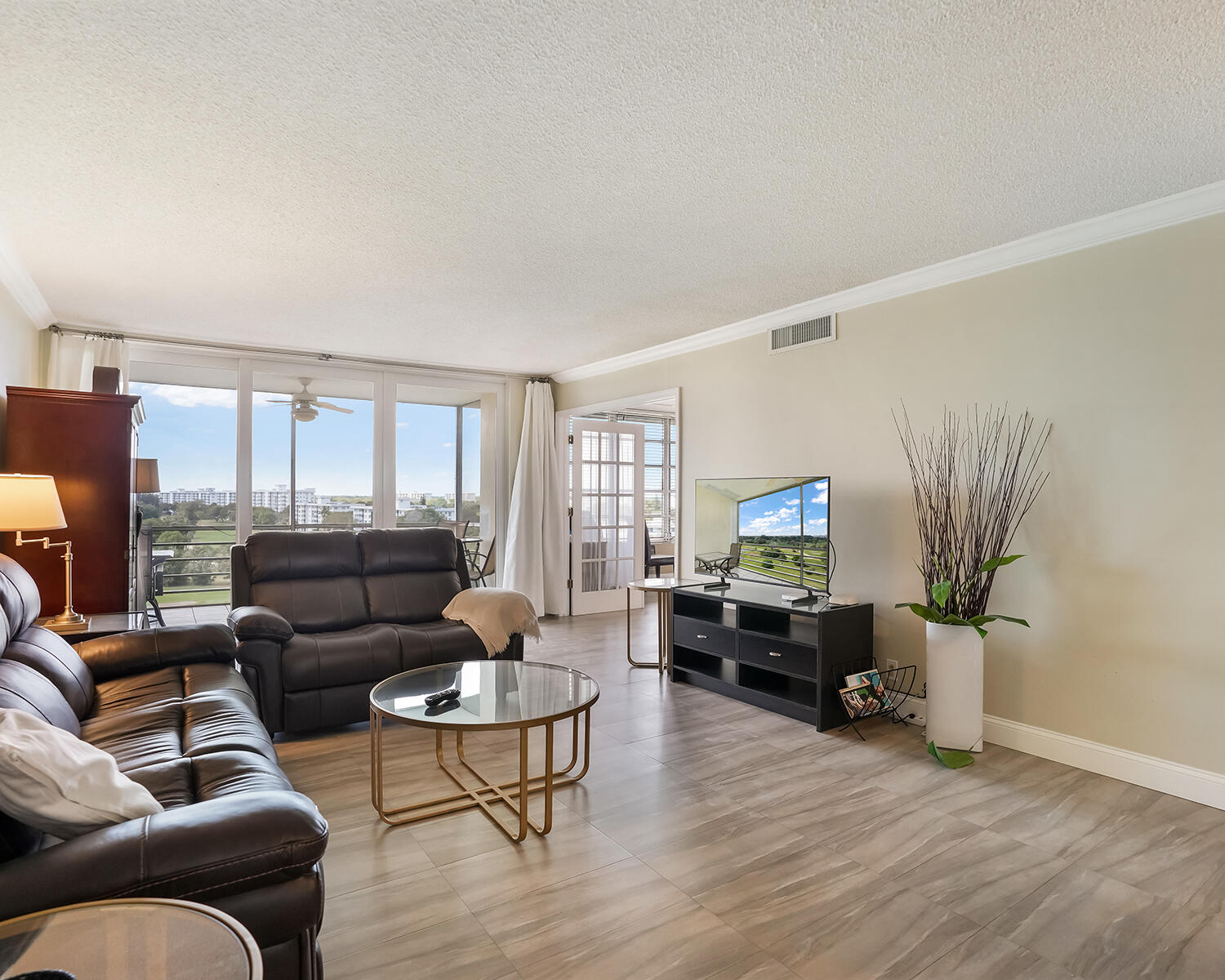 2671 South Course Drive, Unit 907 Pompano Beach, FL 33069 - Photo 4 of 21 a living room with furniture and a flat screen tv