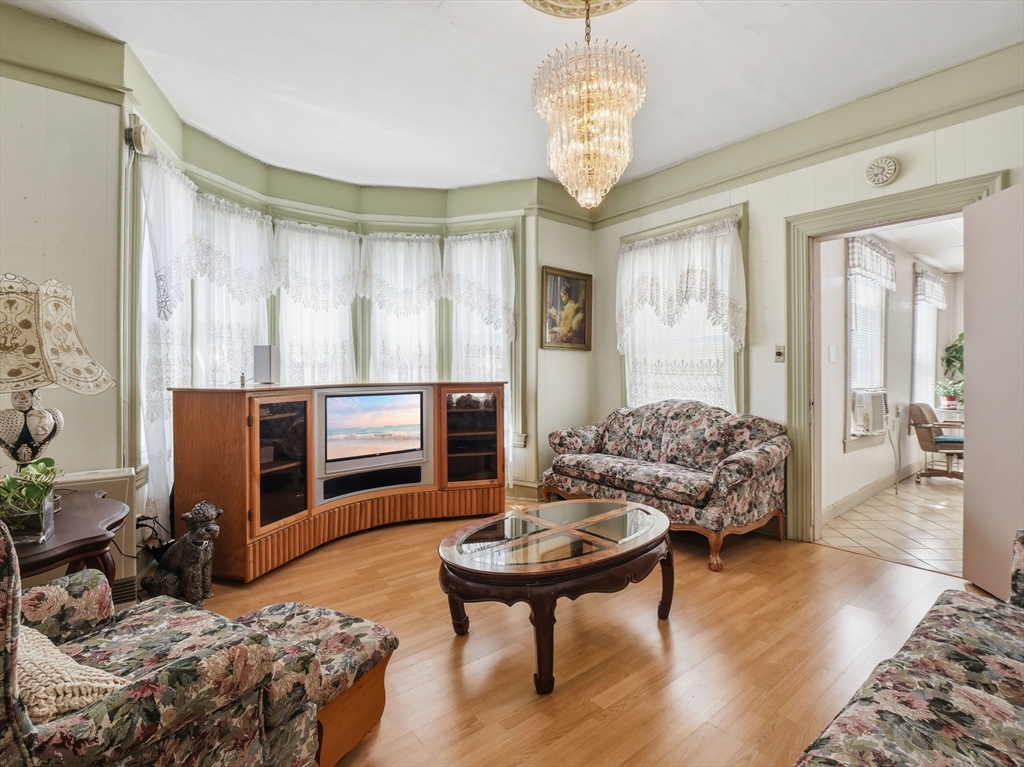 223 Stackpole Street Lowell, MA 01852 - Photo 4 of 42 a living room with furniture and a chandelier