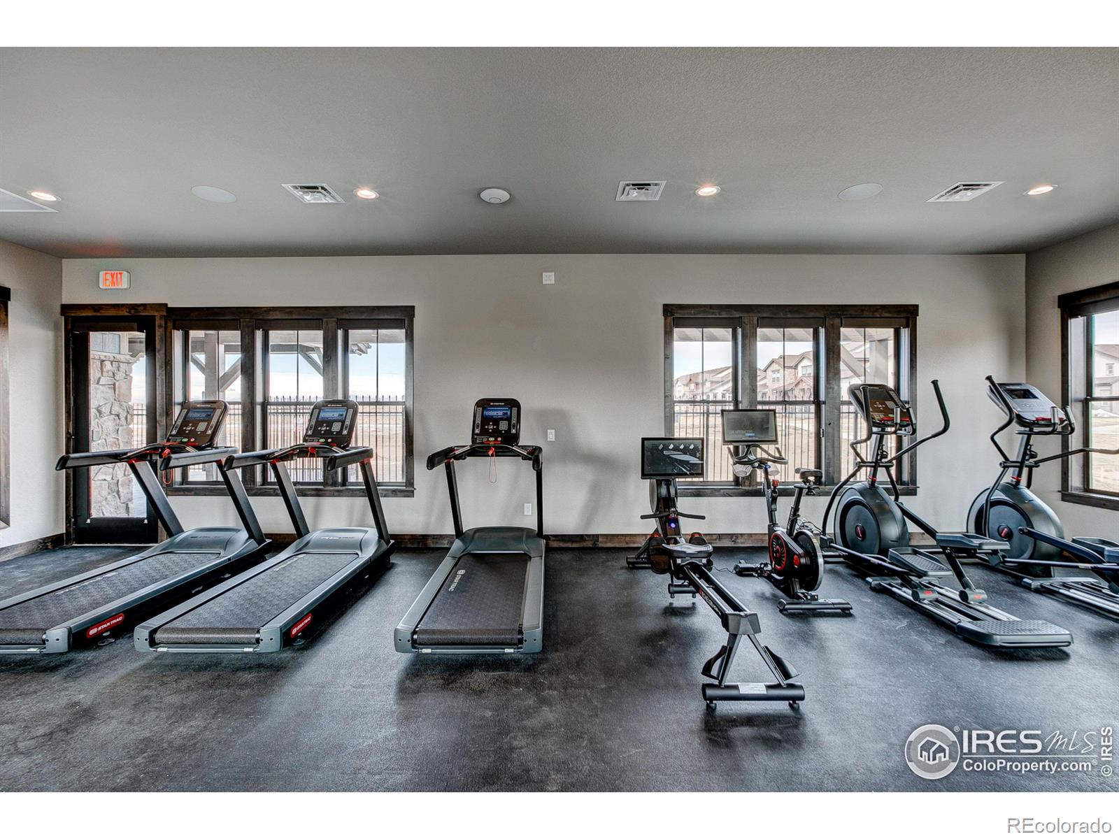 6227 Vernazza Way, Unit 4 Windsor, CO 80550 - Photo 13 of 15 a living room with gym equipment and a large window
