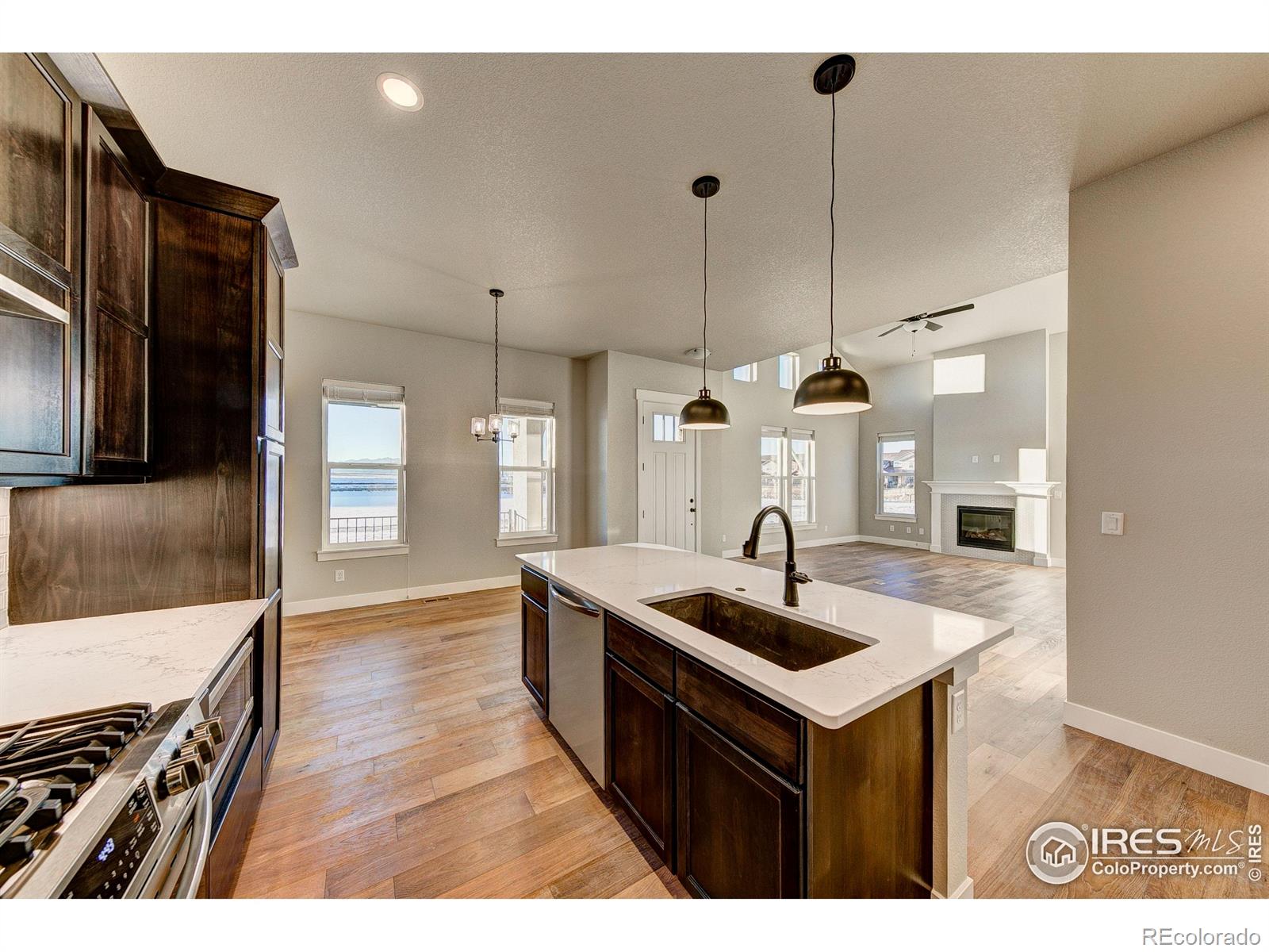 6227 Vernazza Way, Unit 4 Windsor, CO 80550 - Photo 7 of 15 a kitchen with kitchen island a sink and a stove