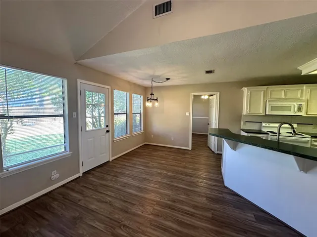 a large kitchen with stainless steel appliances granite countertop a sink and wooden floor