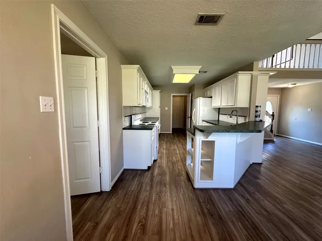 a kitchen with stainless steel appliances kitchen island wooden floors and granite counter tops