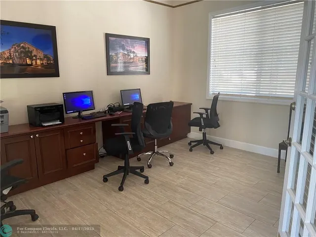 a view of a workspace with furniture and a window