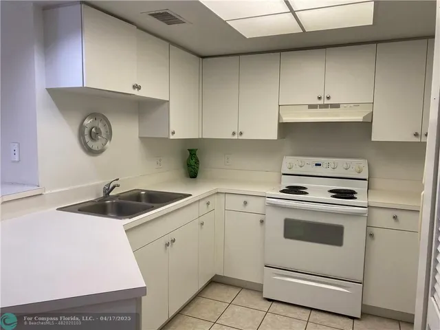 a kitchen with cabinets appliances a sink and a counter top