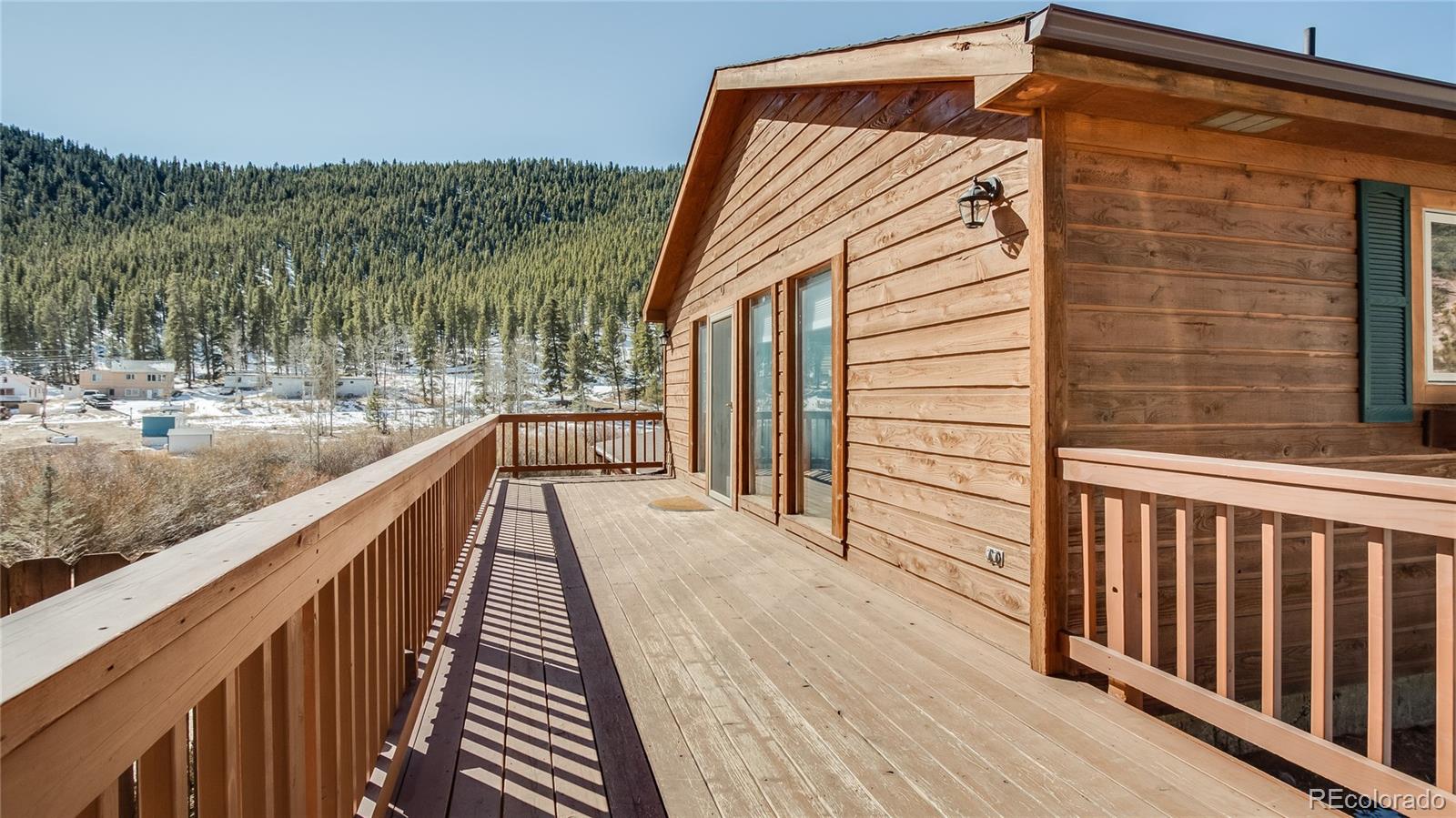 302 Bishop Road Bailey, CO 80421 - Photo 3 of 19 a view of a balcony with wooden floor and fence