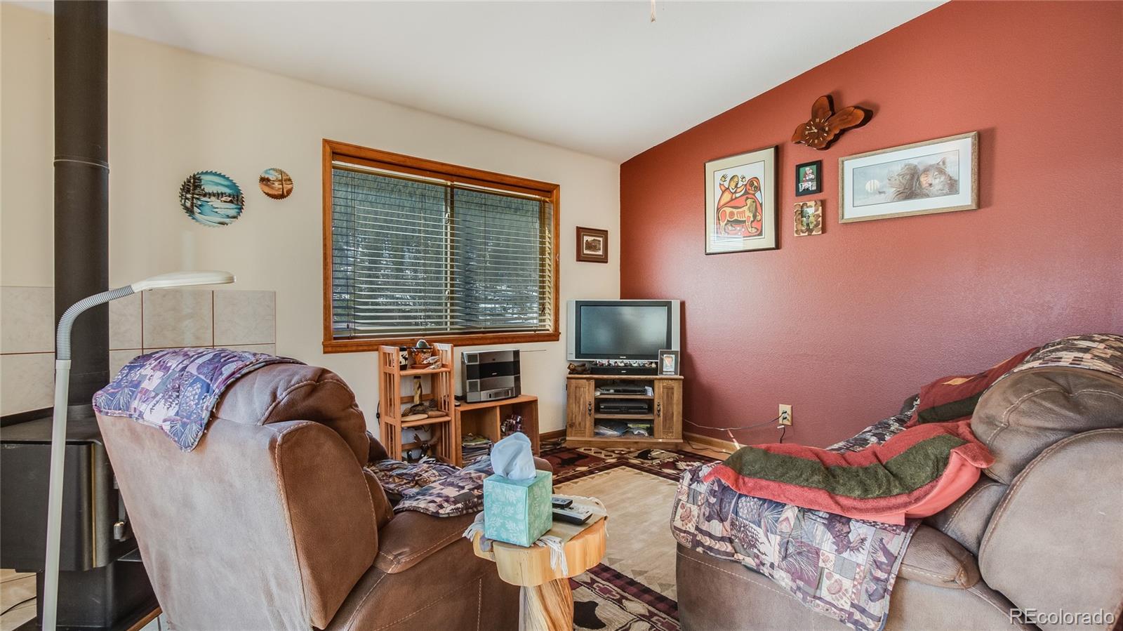 302 Bishop Road Bailey, CO 80421 - Photo 5 of 19 a living room with furniture fireplace and a window