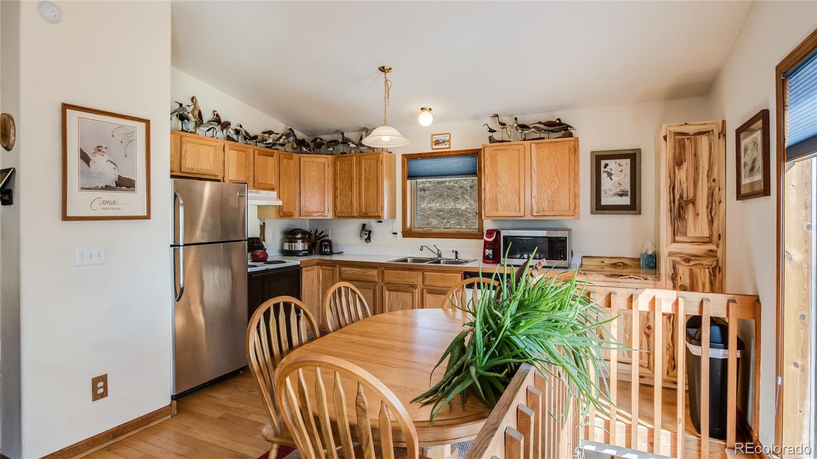 302 Bishop Road Bailey, CO 80421 - Photo 7 of 19 a kitchen with stainless steel appliances granite countertop a refrigerator a stove a sink a dining table and chairs with wooden floor