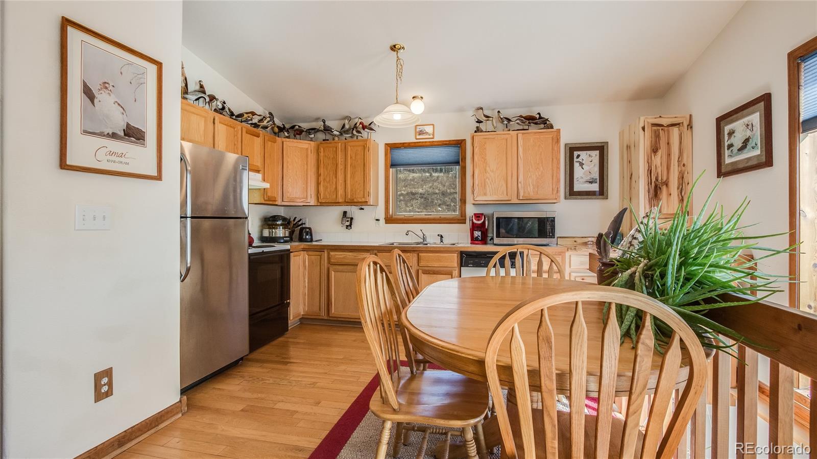 302 Bishop Road Bailey, CO 80421 - Photo 8 of 19 a kitchen with granite countertop a refrigerator a sink a stove and cabinets