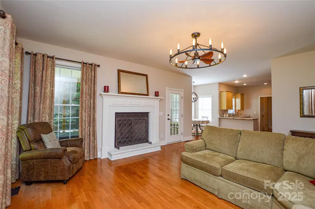 a living room with furniture a fireplace and a large mirror