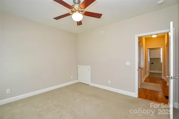 an empty room with closet and a chandelier fan