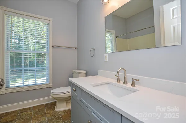 a bathroom with a sink toilet and window
