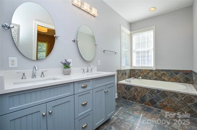 a en suite bathroom with a double vanity sink and a mirror
