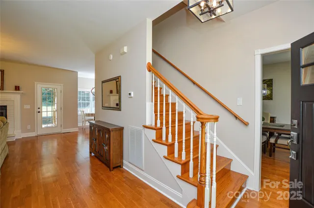 a view of a hallway with wooden floor and staircase