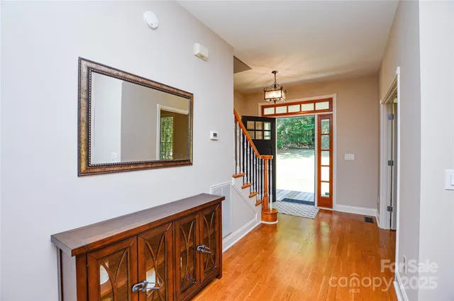 a view of a hallway with wooden floor and an entryway