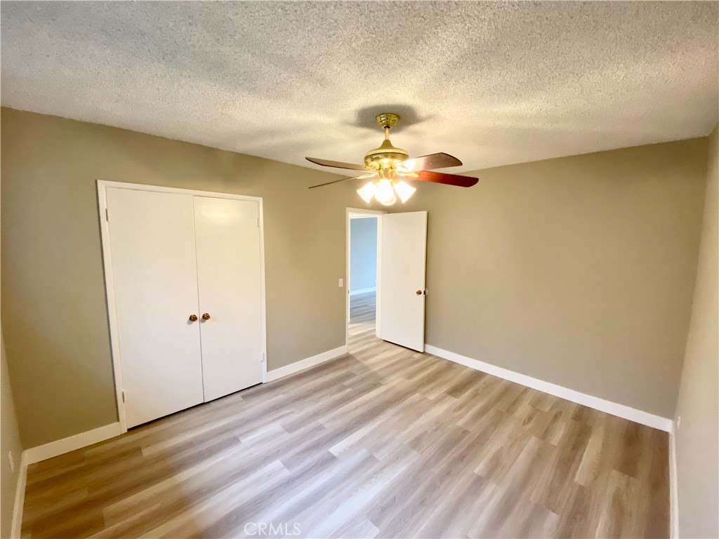 3335 Triangle Place, Unit 5 Glendale, CA 91208 - Photo 6 of 9 an empty room with a chandelier fan and wooden floor