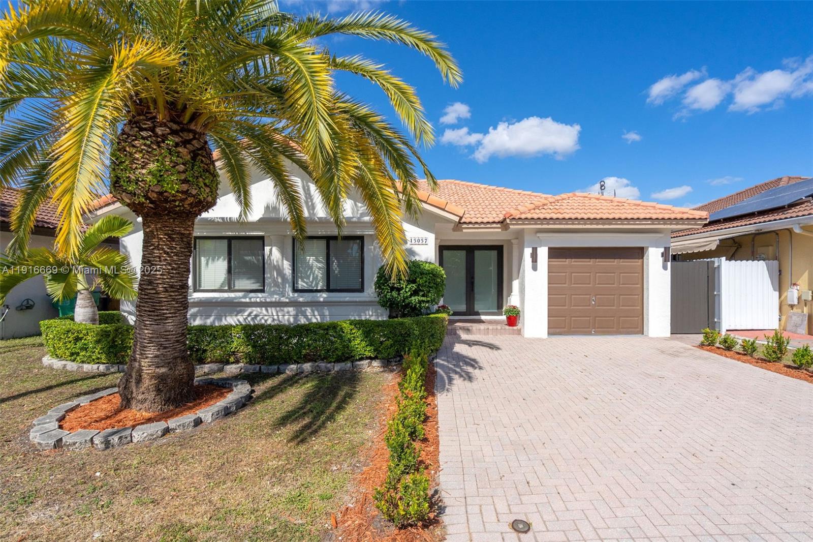 15057 Southwest 32nd Street Miami, FL 33165 - Photo 1 of 31 a view of a white house with a yard and potted plants