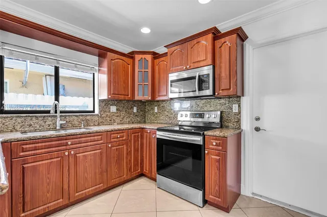 a kitchen with stainless steel appliances granite countertop a stove microwave and sink