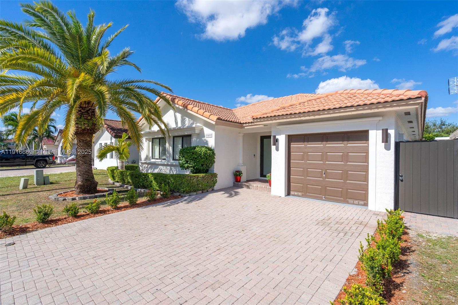 15057 Southwest 32nd Street Miami, FL 33165 - Photo 2 of 31 a front view of a house with a yard and garage