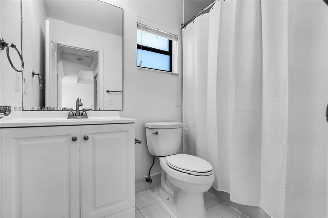 a bathroom with a toilet a sink and a mirror