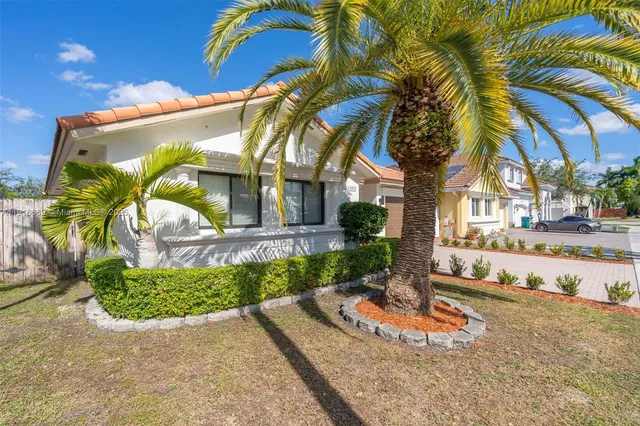 a view of a palm trees front of house