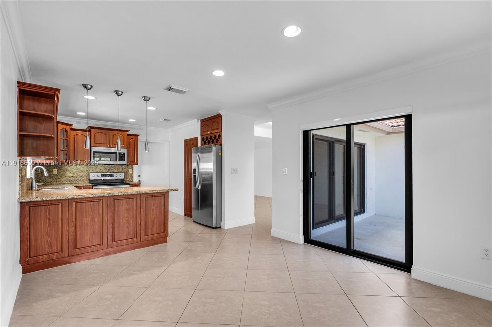 15057 Southwest 32nd Street Miami, FL 33165 - Photo 8 of 31 a large kitchen with stainless steel appliances kitchen island granite countertop a refrigerator and a sink