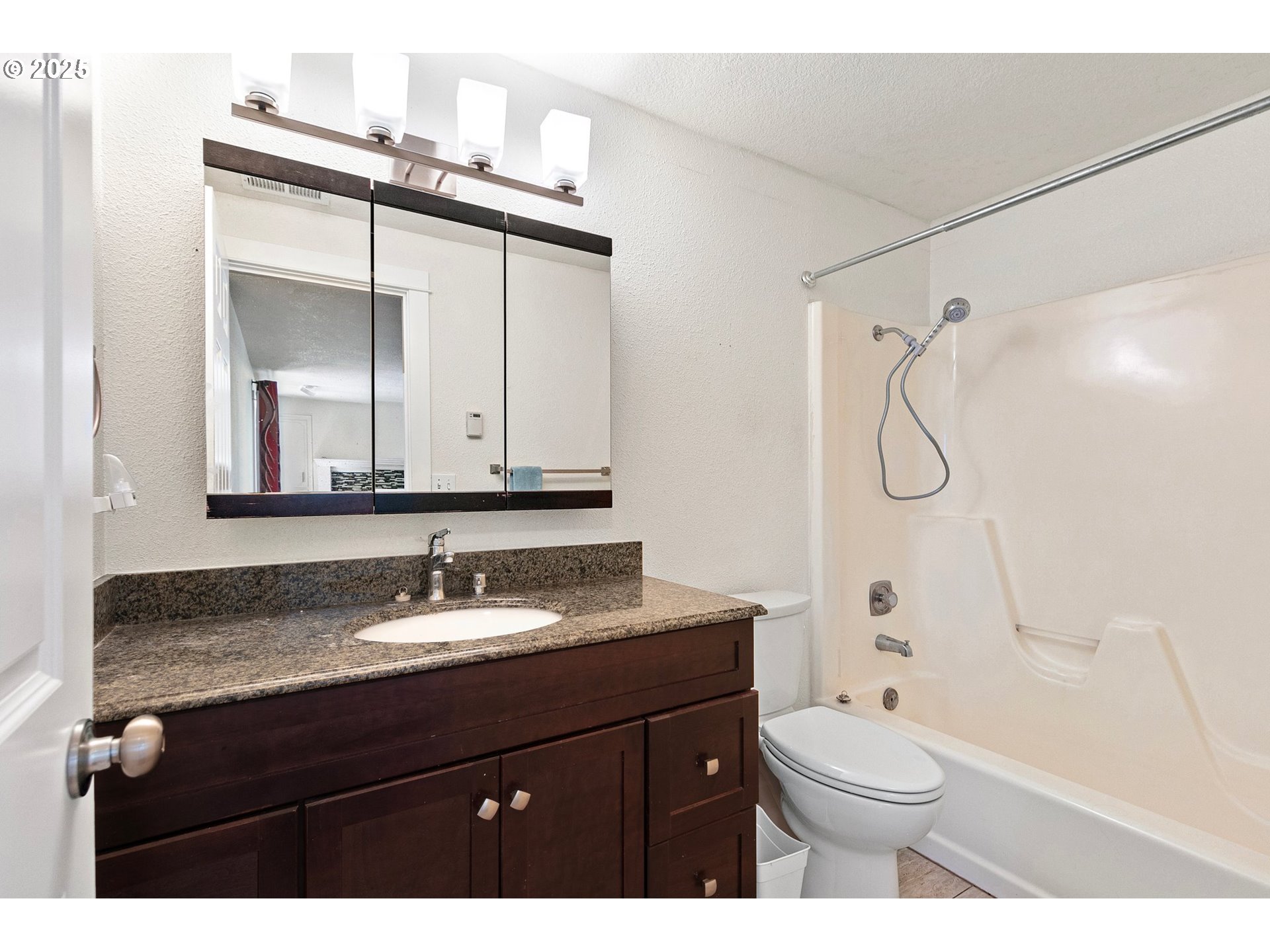 1170 Cal Young Road Eugene, OR 97401 - Photo 17 of 40 a bathroom with a granite countertop sink toilet a mirror and shower