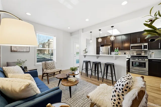 a living room with furniture kitchen and a table