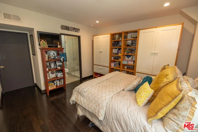 a bedroom with a bed and a wooden floor