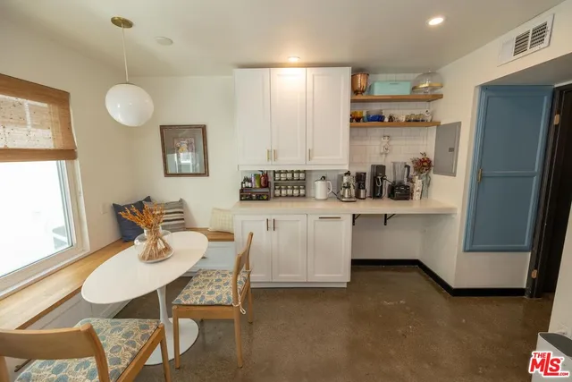 a dining room with furniture and a large window