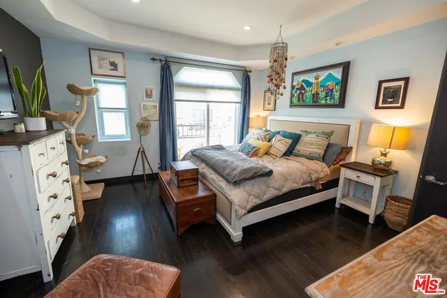 a bedroom with a bed window and dresser