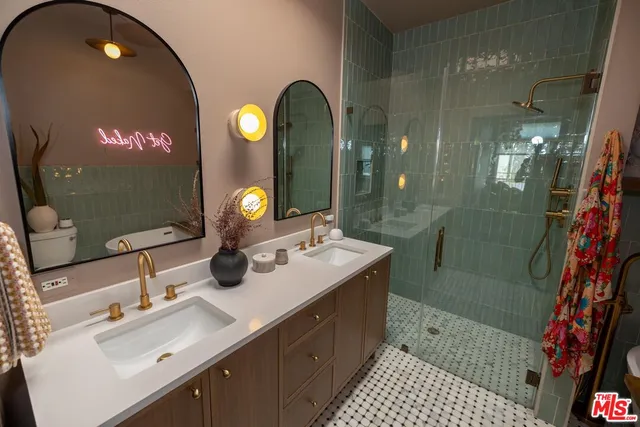 a bathroom with a sink a light fixture and a glass door shower