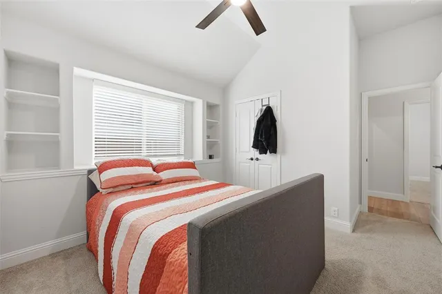 a bedroom with a bed and a flat tv screen on the dresser