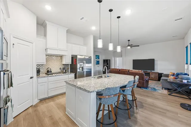 a large kitchen with kitchen island a dining table and chairs