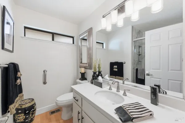 a bathroom with a granite countertop sink mirror vanity and toilet