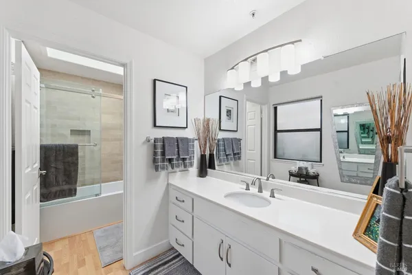 a bathroom with double vanity sink a mirror and shower