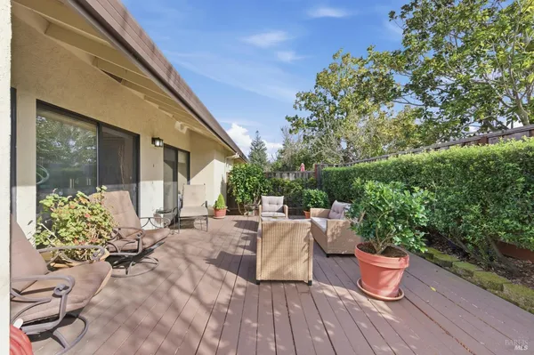 a view of a patio with table and chairs potted plants and large tree