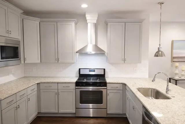 a kitchen with granite countertop white cabinets and white stove